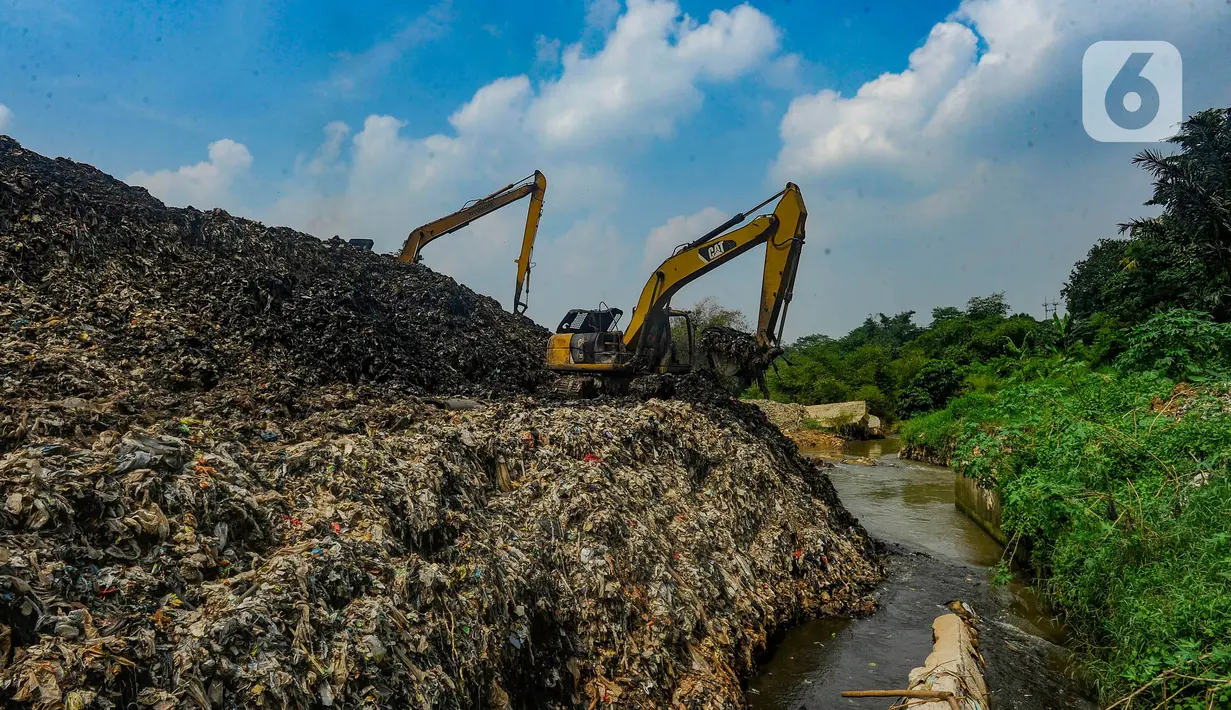 Alat berat mengangkat sampah untuk mengurangi volume longsor tempat pembuangan akhir (TPA) Cipayung yang menimbun Kali Pesanggrahan di Depok, Jawa Barat, Selasa (30/4/2024). (merdeka.com/Arie Basuki)