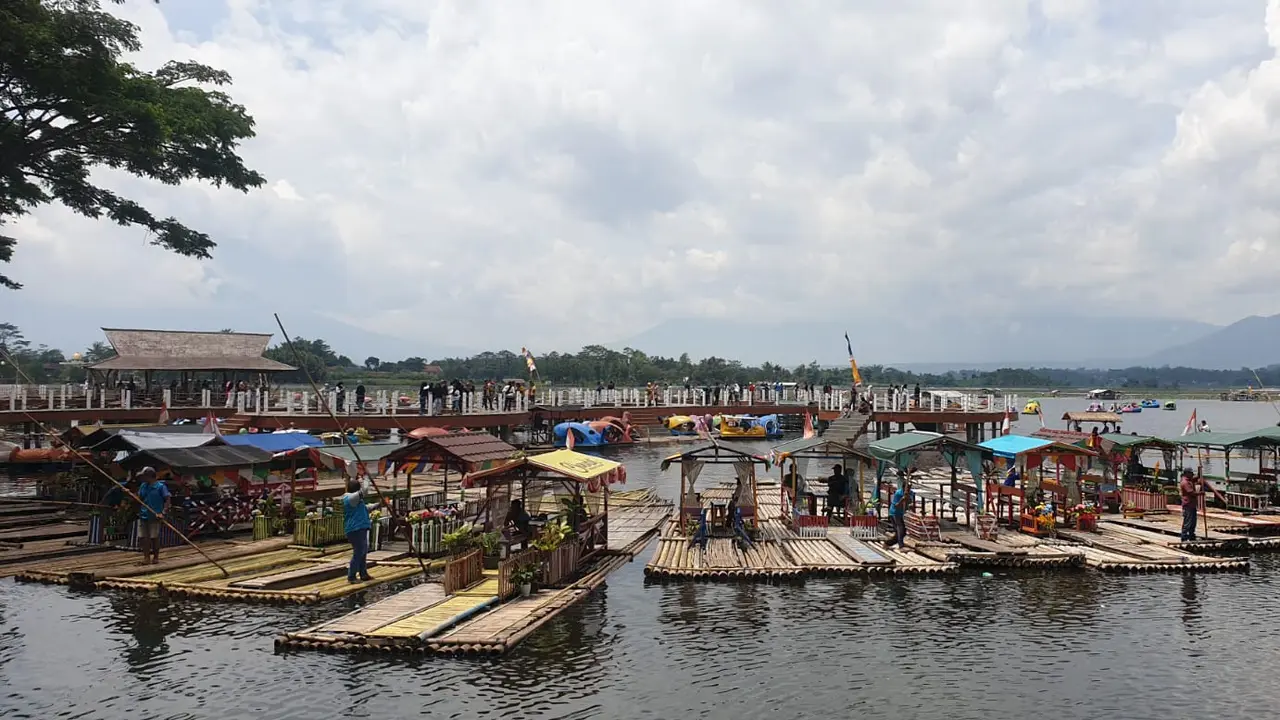 Kilau kawasan wisata Situ Bagendit, Kecamatan Banyuresmi, Garut, Jawa Barat, saat libur lebaran 2023 kali ini tidak memudar. Deretan rakit atau perahu dari bambu siap membawa pengunjung. (Liputan6.com/Jayadi Supriadin)