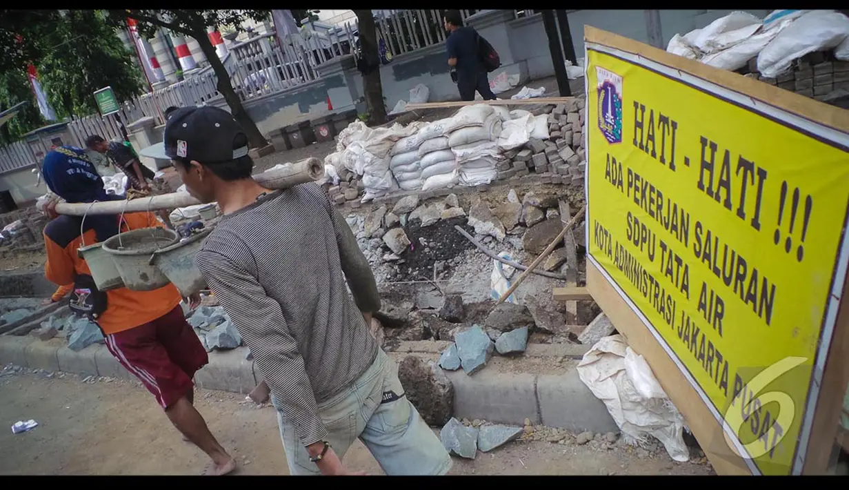 Para pekerja dengan cekatan melaksanakan tugasnya untuk menyelesaikan saluran air ini tepat pada waktunya, Jakarta, Senin (11/8/2014) (Liputan6.com/Faizal Fanani)