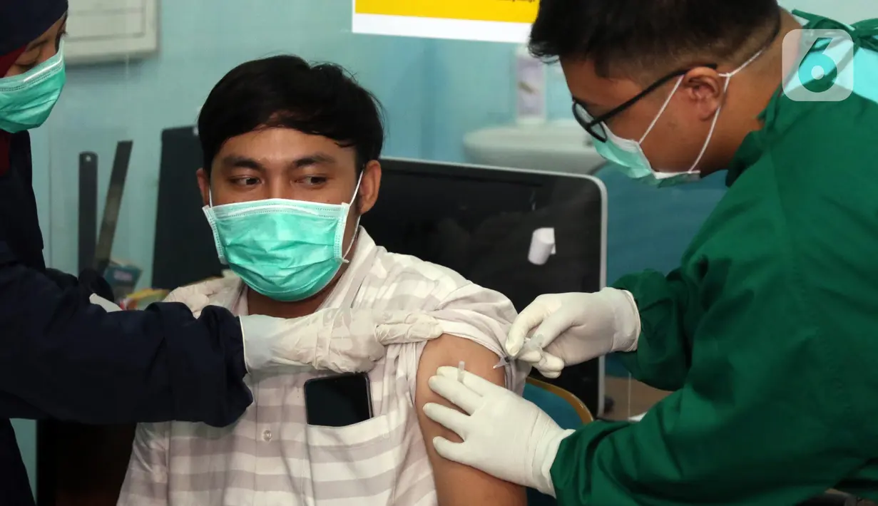 Vaksinator menyuntikkan vaksin COVID-19 kepada tenaga kesehatan yang bertugas di Puskesmas Jurang Mangu, Tangerang Selatan, Jumat (15/1/2021). Program vaksinasi COVID-19 tahap pertama kepada tenaga kesehatan mulai dilakukan di berbagai daerah di Indonesia. (Liputan6.com/Angga Yuniar)