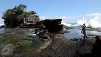 Seorang wisatawan melintas menuju salah satu bangunan pura yang ada di Tanah Lot, Bali, 31 Agustus 2015. Kawasan wisata Tanah Lot masih menjadi primadona bagi wisatawan yang berkunjung ke Bali. (Liputan6.com/Helmi Fithriansyah)