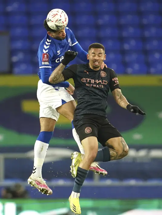 Bek Everton, Ben Godfrey dan penyerang Manchester City, Gabriel Jesus bersaing memperebutkan bola pada perempat final Piala FA 2020/2021 di Goodison Park, Minggu dini hari WIB (21/3/2021). Manchester City lolos ke babak semifinal Piala FA setelah menang 2-0 atas Everton. (AP Photo/Jon Super, Pool)