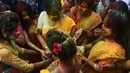 Sejumlah siswi menaburkan bubuk warna selama mengikuti perayaan Holi di Kolkata, India (7/3). Festival ini dikenal dengan acaranya yang khas yaitu saling menaburkan semacam bubuk yang berwarna-warni. (AFP/Dibyangshu)
