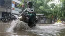 Kendaraan roda dua menerjang banjir di kawasan Kemang Timur, Jakarta, Kamis (4/1/2024).(Liputan6.com/Herman Zakharia)