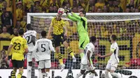 Kiper Real Madrid, Thibaut Coutrois, menyelamatkan gawangnya dari percobaan bek Borussia Dortmund, Nico Schlotterbeck. dalam final Liga Champions 2023/2024 di Stadion Wembley, Minggu (2/6/2024). (AP Photo/Ian Walton)