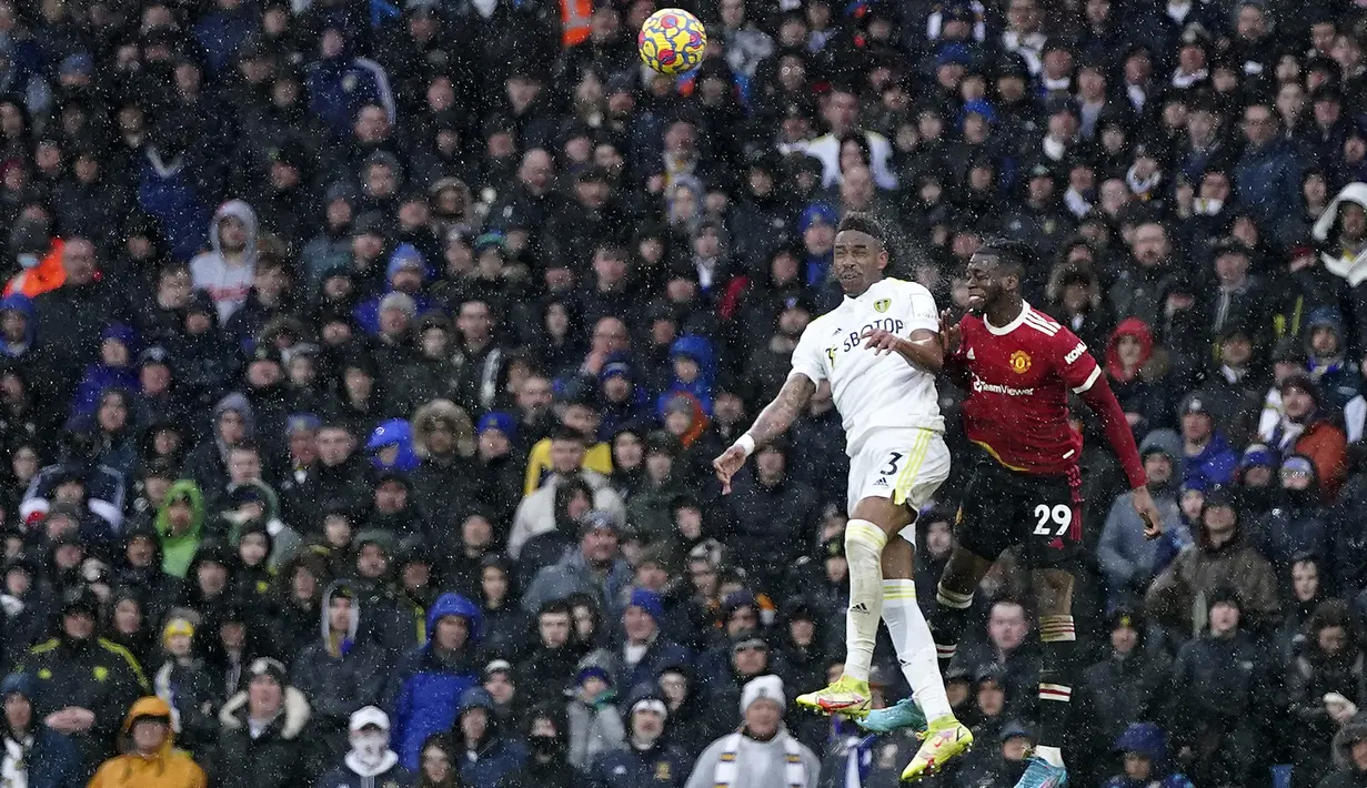 Bek Manchester United, Aaron Wan-Bissaka berebut bola udara dengan pemain Leeds United, Junior Firpo pada pertandingan lanjutan Liga Inggris di Stadion Elland Road di Leeds, Inggris, Minggu (20/2/2022). MU menang atas Leeds United 4-2. (AP Photo/Jon Super)
