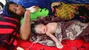 Wanita Rohingya bernama Hasina Aktar terbaring bersama bayinnya usai melahirkan di kamp pengungsian Kutupalong (11/10). Anak Hasina Aktar ini diberi nama Mohammed Jubayed. (AFP Photo/Munir Uz Zaman)