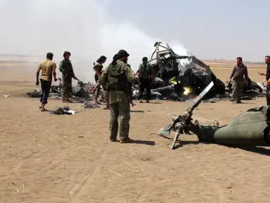 Pemberontak Suriah memeriksa reruntuhan helikopter milik Rusia yang ditembak jatuh di wilayah Idlib, Suriah, Senin (1/8). Helikopter berjenis Mi-8 itu membawa tiga kru dan dua petugas yang diperkirakan tewas. (Mohamed al - Bakour/AFP)