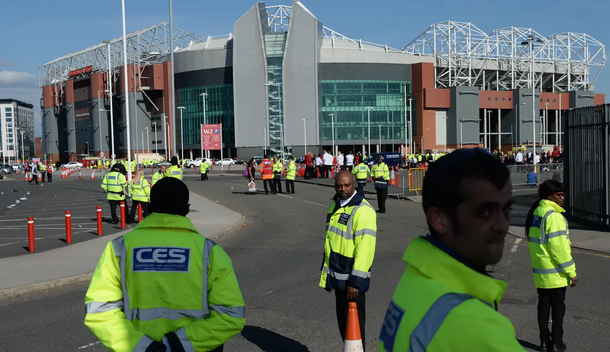 Pihak keamanan di markas MU, Stadion Old Trafford, mengevakuasi penonton di tribun Stretford End dan tribun Sir Alex Ferguson, Inggris, Minggu (15/5). Polisi menemukan sebuah paket mencurigakan di Tribun Notrh West Quadran. (Oli SCARFF/AFP)