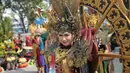 Seorang peserta dengan pakaian adat wanita Kalimantan Tengah saat mengikuti rangkaian acara Festival Budaya Isen Mulang di Bundaran Palangkaraya, Minggu (19/5/24) pagi. (Bola.com/Ade Yusuf Satria)