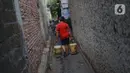 Warga membawa ember berisi air bersih di kawasan Cipayung, Jakarta Timur, Rabu (20/11/2019). Warga memanfaatkan bantuan air bersih dari Pemprov DKI Jakarta untuk memenuhi kebutuhan sehari-hari. (Liputan6.com/Immanuel Antonius)