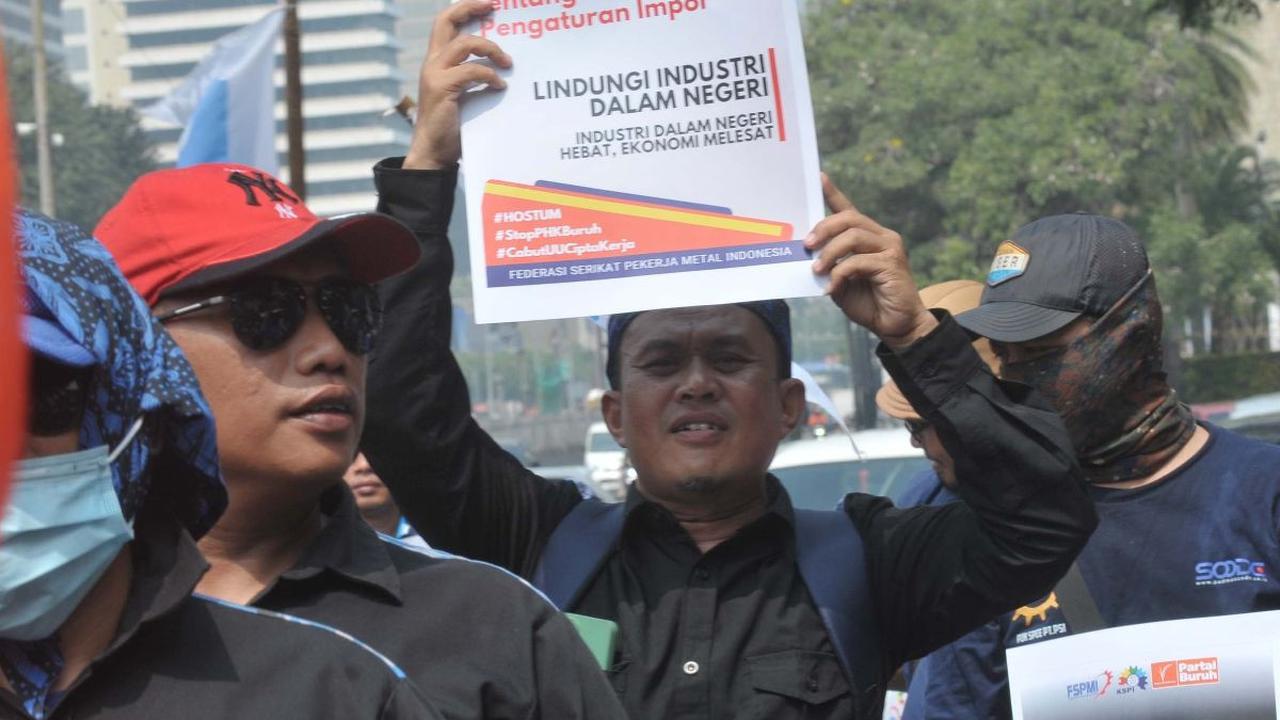 Massa buruh menggelar aksi unjuk rasa di Kawasan Patung Kuda, Jakarta, Rabu (3/7/2024). <br><br>Aksi tersebut mereka lakukan untuk menuntut kepada pemerintah soal penghentian ancaman PHK puluhan ribu buruh. Foto: merdeka.com / imam buhori <br>