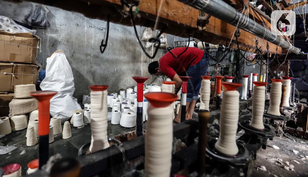 Pekerja memintal benang di Kebayoran, Jakarta, Selasa (5/7/2022). Pabrik benang yang berdiri sejak tahun 1970-an tersebut dapat memproduksi 100 kilogram benang dalam sehari dan dipasarkan ke berbagai daerah di Indonesia. (Liputan6.com/Johan Tallo)