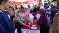 Kasespim Irjen Pol Wahyu Indra Pramugari melayani warga saat bazar murah di Asrama Unit Barat, Jawa Barat, Senin (04/6). Sekolah Staf dan Pemimpin Tinggi Polri (Sespimti) menggelar bakti sosial, bazar murah dan paket lebaran. (Liputan6.com/Pool/Sespimti)