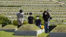 Anggota keluarga memberi penghormatan kepada pemakaman leluhur mereka menjelang liburan Chuseok di sebuah pemakaman di Paju, Korea Selatan (12/9/2021).  Penutupan pemakaman selama lima hari dari 18 September hingga 22 September untuk mencegah penyebaran virus corona. (AP Photo/Ahn Young-joon)