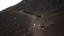 Foto pada 18 Juli 2021 menunjukkan orang-orang turun dari puncak Gunung Fuji, barat Tokyo. Mendaki Gunung Fuji bukanlah hal yang mudah, tetapi pemandangan matahari terbit di atas lautan awan adalah hadiah terindah bagi yang mencapai puncak tertinggi di Jepang. (Charly TRIBALLEAU/AFP)