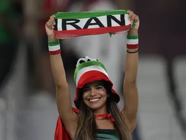 Seorang fans wanita Iran tersenyum menjelang pertandingan  grup B Piala Dunia antara Iran melawan Amerika Serikat di Stadion Al Thumama di Doha, Qatar, Selasa, 29 November 2022. (AP Photo/Ebrahim Noroozi)