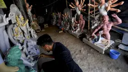 Seorang perajin mengerjakan pembuatan patung Dewi Durga jelang Festival Durga Puja di sebuah bengkel di New Delhi, India, Rabu (29/9/2021). (MONEY SHARMA/AFP)
