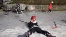 Anak-anak bermain hoki es di kanal beku saat Olimpiade Musim Dingin 2022 hampir berakhir di Beijing pada Sabtu, 19 Februari 2022. (AP Photo/Ng Han Guan)