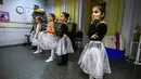 Gadis-gadis kecil mengikuti kelas balet di sebuah studio di Moskow , 22 November 2018. Orang tua dan kakek-nenek duduk di koridor sebuah studio kecil di Moskow utara menunggu anak-anak usia tiga tahun menyelesaikan kelas balet mereka. (Mladen ANTONOV/AFP)