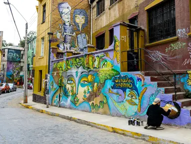 Seniman Sammy Espinosa menyelesaikan mural jalanan di Valparaiso, Chile, 9 April 2019. Valparaiso menjadi galeri seni terbuka raksasa. (Martin BERNETTI/AFP)