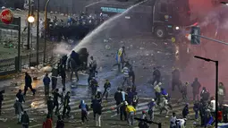 Untuk membubarkan massa, aparat kepolisian setempat terpaksa menyemprotkan air ke arah suporter yang berkerumun di sebuah area terbuka di Buenos Aires, (14/7/2014). (REUTERS/Ivan Alvarado) 