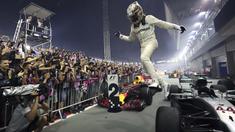 Pebalap Mercedes, Lewis Hamilton merayakan kemenangan saat menjuarai F1 Singapura di  Marina Bay City Circuit, (17/9/2017).  (AP/Yong Teck Lim)