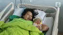 Regina (43) memeluk bayinya Glowy Lidwina usai menjalani proses persalinan di RSUD Pasar Minggu, Jakarta, Kamis (20/2/2020). Bayi perempuan dari pasangan Regina dan Andre (47) bernama Glowy Lidwina lahir secara sesar di tanggal 20 bulan 02 tahun 2020 atau 20-02-2020. (Liputan6.com/Herman Zakharia)