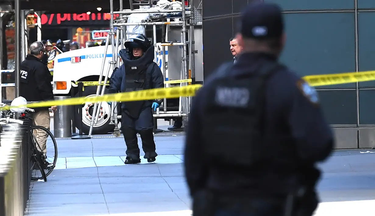 Petugas penjinak bom keluar dari Gedung Time Warner setelah paket bom pipa dikirimkan di mana kantor CNN New York beroperasi, Rabu (24/10). Paket tampak seperti pipa dan ada jaringan kabelnya ditemukan di kotak surat kantor CNN. (TIMOTHY A. CLARY/AFP)