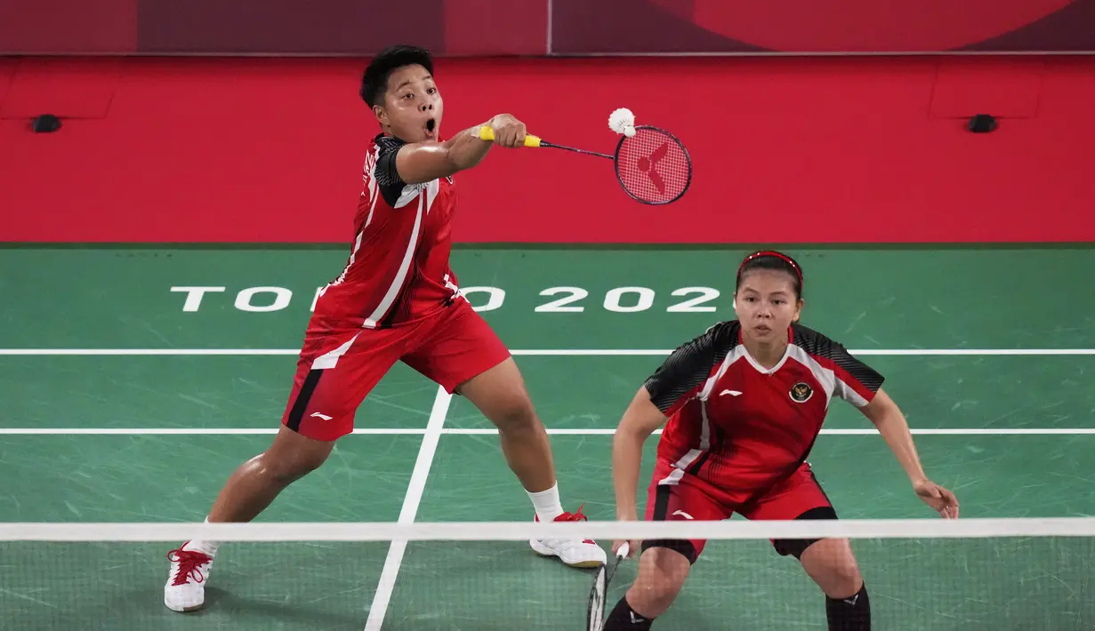 Ganda putri Indonesia Greysia Polii dan Apriyani Rahayu (belakang) saat melawan Chow Mei Kuan dan Lee Meng Yean dari Malaysia pada pertandingan pertama Grup A bulu tangkis Olimpiade Tokyo 2020 di Musashino Forest Sport Plaza, Sabtu (24/7/2021). Greysia / Apriyani menang 21-17. (AP/Markus Schreiber)