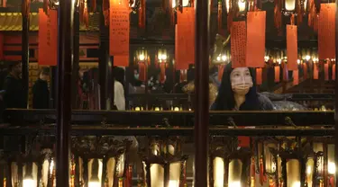 Umat berdoa di depan lentera selama perayaan Tahun Baru Imlek di kuil Man Mo di Hong Kong Selasa, 1 Februari 2022. Perayaan tersebut menandai Tahun Macan dalam kalender zodiak China. (AP Photo/Vincent Yu)
