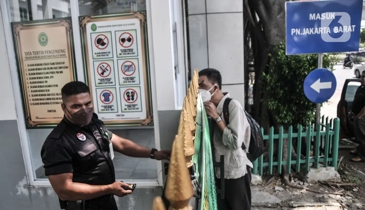 Petugas keamanan memberitahukan kepada pengunjung terkait penutupan sementara PN Jakarta Barat, Kamis (27/1/2022).   Penutupan dilakukan menyusul temuan kasus 13 orang yang terdiri dari hakim dan pegawai di Pengadilan Negeri Jakarta Barat positif terpapar Covid-19. (Merdeka.com/Iqbal S. Nugroho)