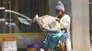 Seorang pedagang membaca koran saat menunggu pembeli di Harare, Zimbabwe, Selasa (5/1/2021). Menanggapi meningkatnya infeksi COVID-19, Zimbabwe telah memberlakukan kembali jam malam, melarang pertemuan publik, dan menangguhkan pembukaan sekolah tanpa batas waktu. (AP Photo/Tsvangirayi Mukwazhi)