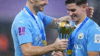 Jack Grealish (kiri) dan Julian Alvares (kanan) menatap trofi Piala Dunia Antarklub 2023 setelah Man City berhasil keluar sebagai juara di King Abdullah Sports City Stadium, Sabtu (23/12/2023) dini hari WIB.&nbsp;(AP Photo/Manu Fernandez)