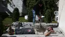 Mohamed Barka, pria yang dijuluki "Super Hero" asal Palestina menjadikan tubuhnya sebagai bantalan untuk menghancurkan batu bata beton dalam aksinya di Deir Al-Balah, Gaza Tengah, Kamis (4/2). (MOHAMMED ABED/AFP)