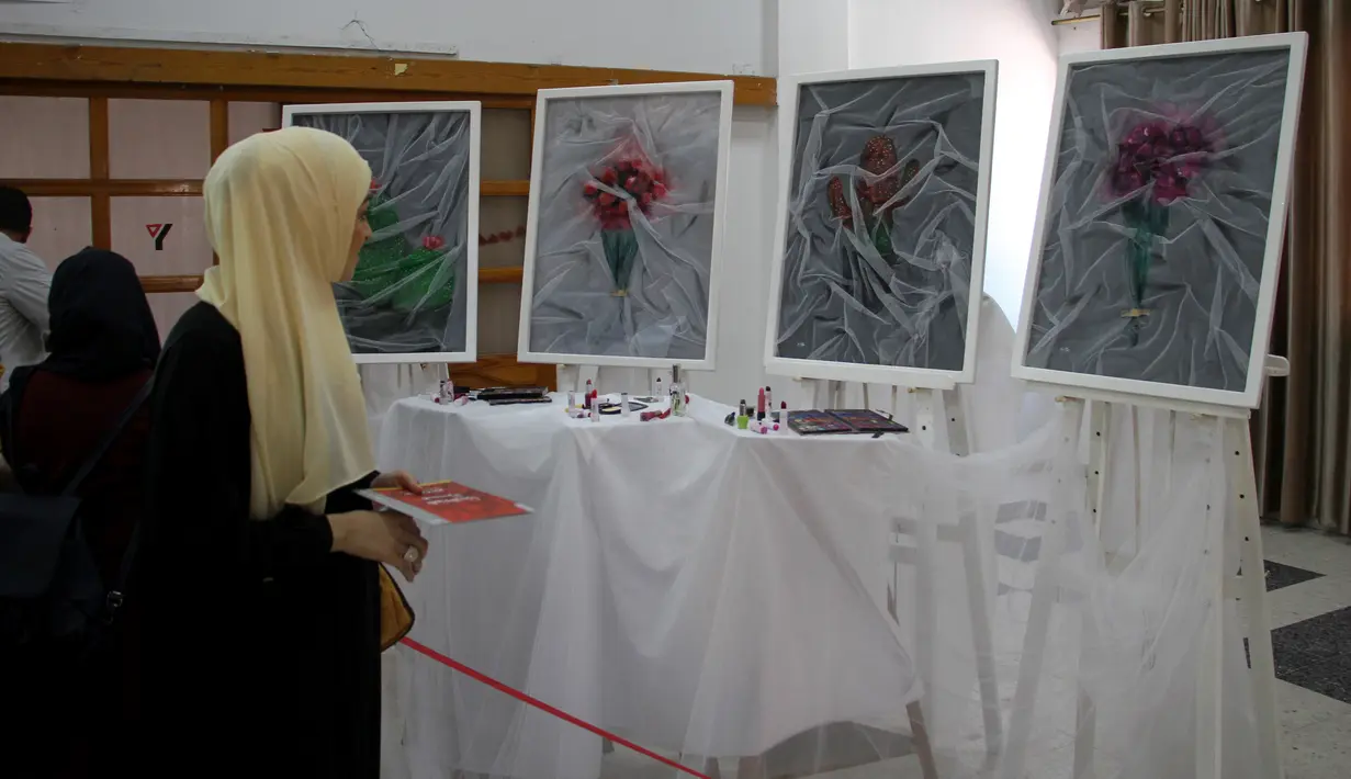 Seorang perempuan mengunjungi pameran seniman Palestina Kholoud al-Dasooqi di Gaza City, 11 Agustus 2020. Seniman Palestina asal Kota Khan Younis di Jalur Gaza itu menggelar pameran selama dua hari untuk mengungkap kekerasan terhadap perempuan melalui puluhan lukisan. (Xinhua/Rizek Abdeljawad)