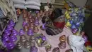 Perajin mewarnai pot minyak tembikar atau diyas menjelang Diwali, festival lampu Hindu, di Hyderabad (4/11/2020). Selama perayaan Diwali, para warga melakukan ritual pembersihan, mulai dari membersihkan dan menghias rumah, berkumpul untuk pesta-pesta khusus. (AFP Photo/Noah Seelam)
