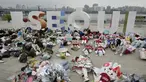 Aktivis lingkungan mengenakan pakaian yang terbuat dari sampah plastik berbaring di tanah selama kampanye untuk memperingati Hari Bumi melawan perubahan iklim di Seoul, Korea Selatan, Jumat (22/4/2022). (AP Photo/Ahn Young-joon)