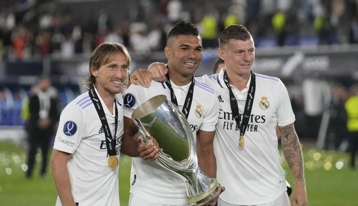 Gelandang Real Madrid, Luka Modric, Toni Kroos dan Casemiro berpose denga trofi usai pertandingan melawan Eintracht Frankfurt pada final Piala Super Eropa di Stadion Olimpiade Helsinki, Finlandia, Kamis (11/8/2022). Real Madrid menang atas Eintracht Frankfurt 2-0. (AP Photo/Antonio Calanni)