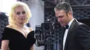 Aktor Taylor Kinney terlihat menggandeng sang tunangan yang juga penyanyi nyentrik, Lady Gaga saat menghadiri ajang penghargaan film tahunan, Golden Globes 2016 di Beverly Hilton Hotel, California, Minggu (10/1). (AFP PHOTO/VALERIE MACONA)