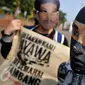 Sekelompok masyarakat mengenakan topeng wajah Salim Kancil saat menggelar aksi di depan Istana Negara, Jakarta, Kamis (1/10/2015). Dalam aksinya mereka menuntut keadilan bagi Salim Kancil dan Tosan. (Liputan6.com/Gempur M Surya)
