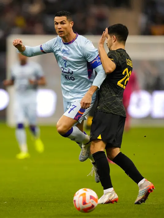 <p>Pemain Riyadh All Star Cristiano Ronaldo (kiri) berebut bola dengan pemain Paris Saint-Germain (PSG) Carlos Soler pada pertandingan sepak bola persahabatan di King Saud University Stadium, Riyadh, Arab Saudi, 19 Januari 2023. PSG mengalahkan Riyadh All Star dengan skor 5-4. (AP Photo/Hussein Malla)</p>