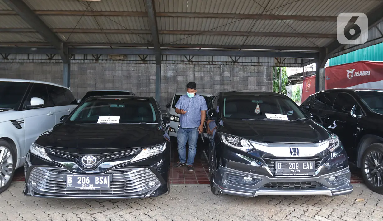 Petugas beraktivitas di dekat kendaraan sitaan dari tersangka tindak pidana korupsi PT Asabri di Kantor Pusat PT ASABRI (Persero), Cawang, Jakarta, Sabtu (12/6/2021). Lelang mobil hasil sitaan kasus korupsi PT Asabri dilakukan pada 15 Juni 2021 pukul 09.00-11.00 WIB. (Liputan6.com/Herman Zakharia)