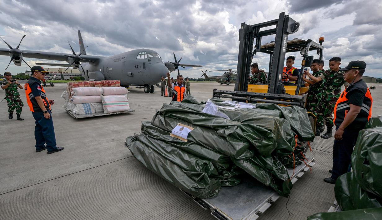 Personel TNI Angkatan Udara dan petugas Badan Nasional Penanggulangan Bencana (BNPB) bersiap memasukkan bantuan kemanusiaan dari pemerintah Indonesia untuk korban gempa bumi di Myanmar ke dalam pesawat angkut Hercules C-130 di Pangkalan Udara Halim Perdanakusuma, Jakarta, 31 Maret 2025. (BAY ISMOYO/AFP)