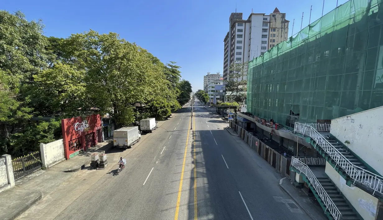Seseorang mengendarai sepeda di jalan kosong di pusat kota Yangon, Myanmar, Jumat (10/12/2021). Aktivis anti-kudeta meminta orang-orang untuk tinggal di rumah dan menutup bisnis untuk memprotes pengambilalihan militer Myanmar yang menggulingkan pemerintah terpilih Aung San Suu Kyi. (AP Photo)