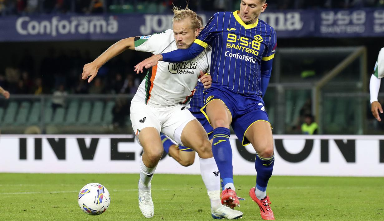 Pemain Venezia, Joel Pohjanpalo (kiri) berebut bola dengan pemain Hellas Verona, Giangiacomo Magnani pada laga lanjutan Liga Italia 2024/2025 di Marcantonio Bentegodi Stadium, Italia, Sabtu (05/10/2024) WIB. (AP Photo/LaPresse/Paola Garbuio)