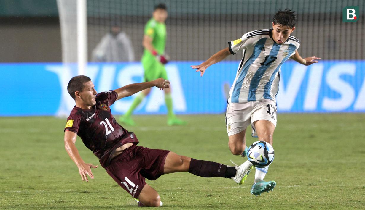 <p>Pemain Timnas Argentina U-17, Valentino Acuna (kanan) berebut bola dengan pemain Timnas Venezuela U-17, Nicola Profeta pada laga 16 besar Piala Dunia U-17 2023 di Stadion Si Jalak Harupat, Bandung, Selasa (21/11/2023). (Bola.com/Ikhwan Yanuar)</p>