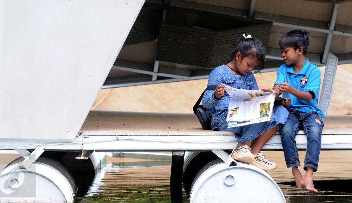 Sejumlah anak sedang membaca di perpustakaan mini 'Ayodya Script' di Taman Ayodya, Blok M, Kebayoran Baru, Jakarta Selatan (22/12/2015). Perpustakaan tersebut dibangun untuk menarik minat warga khususnya anak-anak dan remaja. (Liputan6.com/Helmi Afandi)