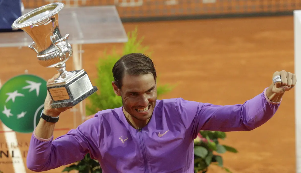 Petenis Spanyol, Rafael Nadal memegang trofi juara turnamen tenis Italia Terbuka 2021 setelah mengalahkan petenis Serbia, Novak Djokovic di Foro Italico, Roma, Minggu (16/5/2021). Rafael Nadal menang dalam pertarungan tiga set 7-5, 1-6, dan 6-3 selama dua jam 49 menit. (AP Photo/Gregorio Borgia)