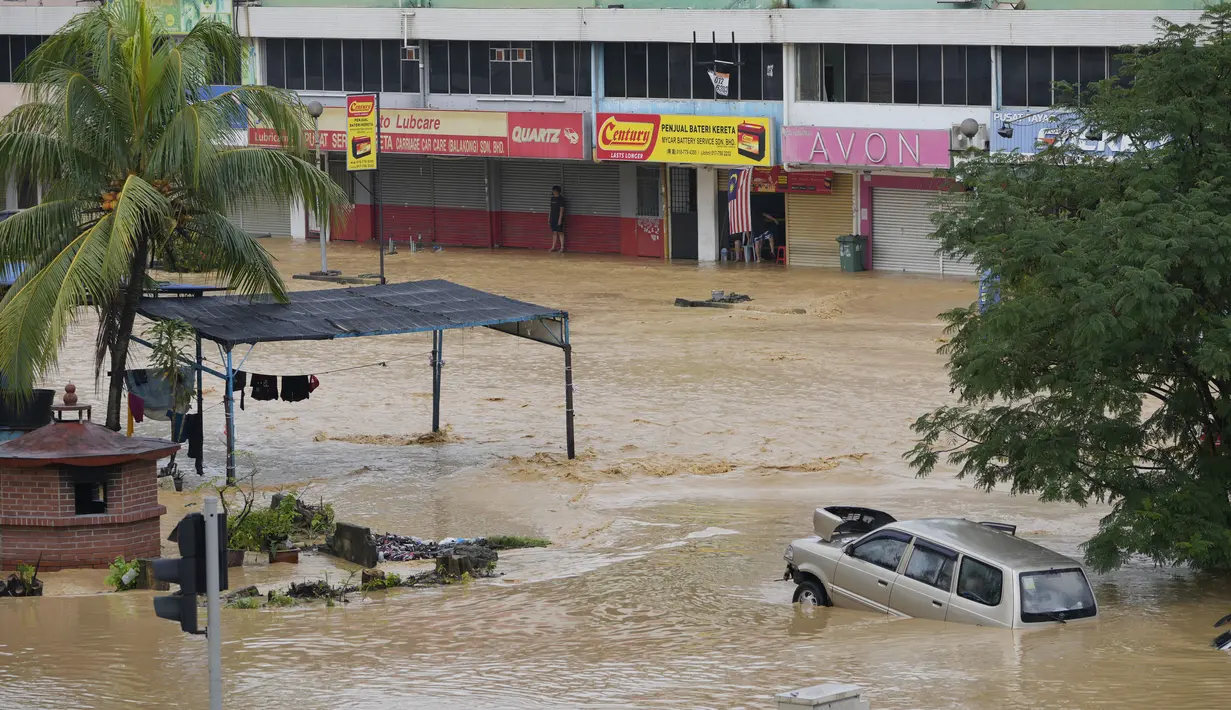 Seorang terdampar menunggu penyelamatan di Hulu Langat, luar Kuala Lumpur, Malaysia, Minggu (19/12/2021). Kuala Lumpur dan perkampungan sekitarnya dilanda banjir akibat hujan deras selama dua hari, menyebabkan ribuan warga mengungsi dan banyak jalan yang memutus akses. (Foto AP/Vincent Thian)
